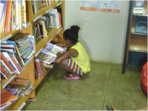 Criança conhecendo o acervo da Biblioteca Multicultural Nascedouro
